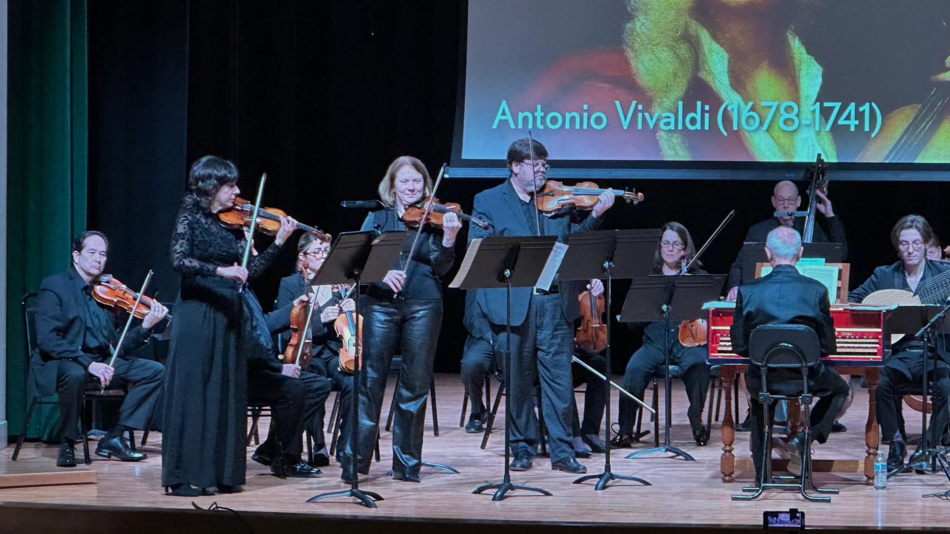 Gina DiBello, Katie Brauer, and Kevin Case stand playing their violins