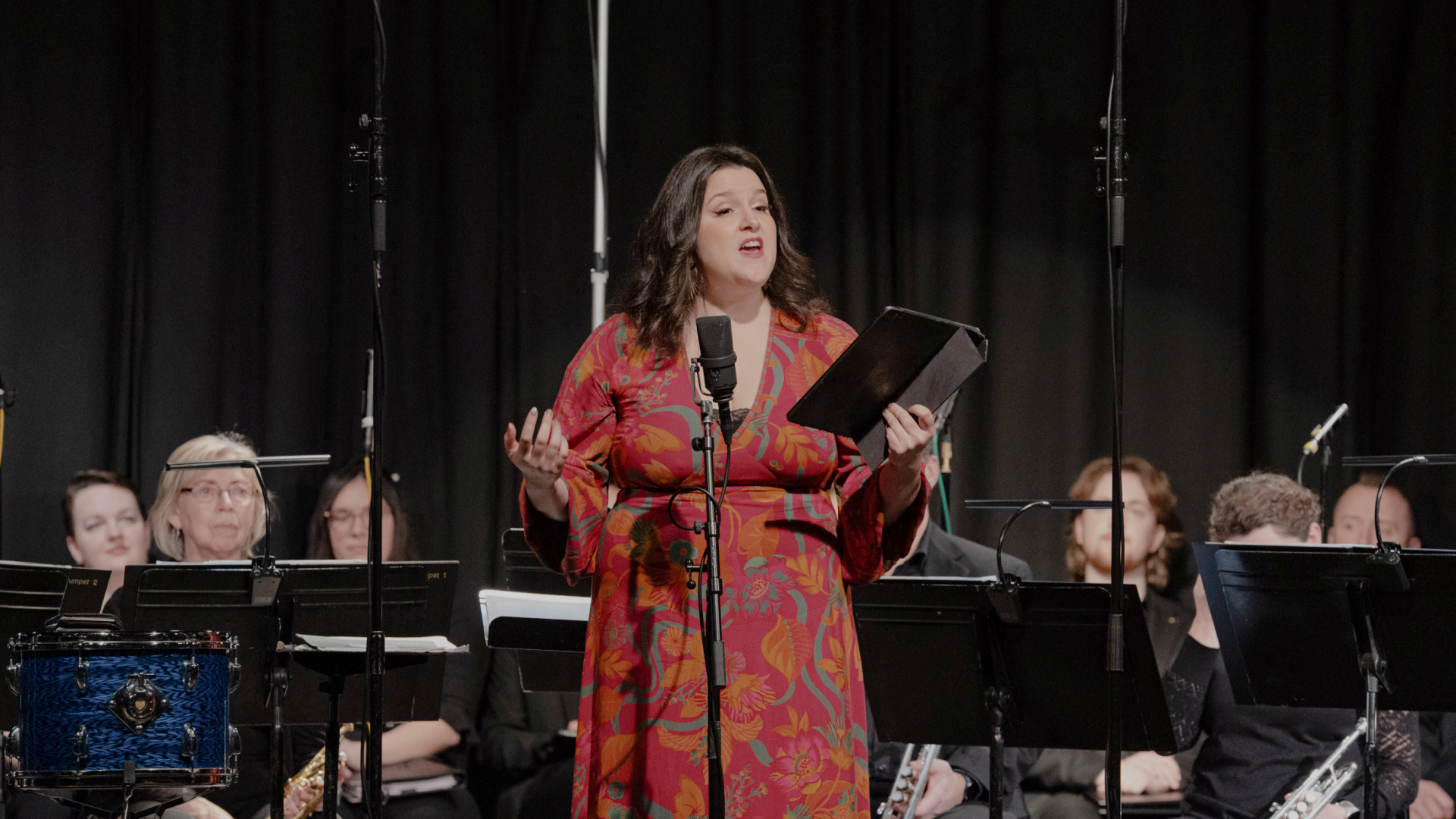 soprano Estelí Gomez singing in a red dress